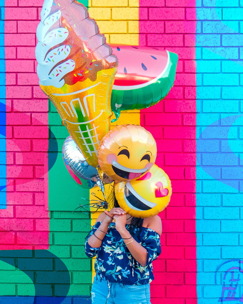 woman holding up balloons