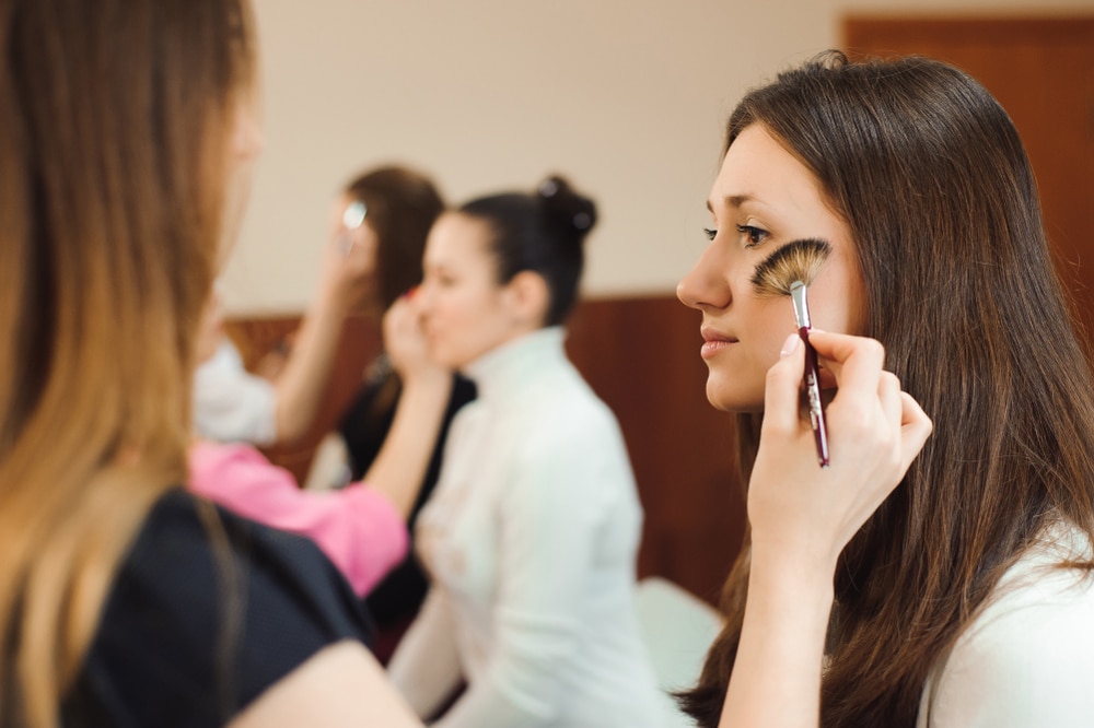 cosmetologist putting makeup on client