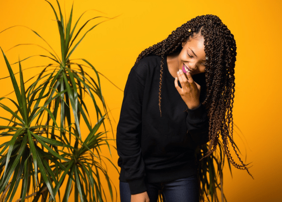 woman giggling and smiling on a yellow background