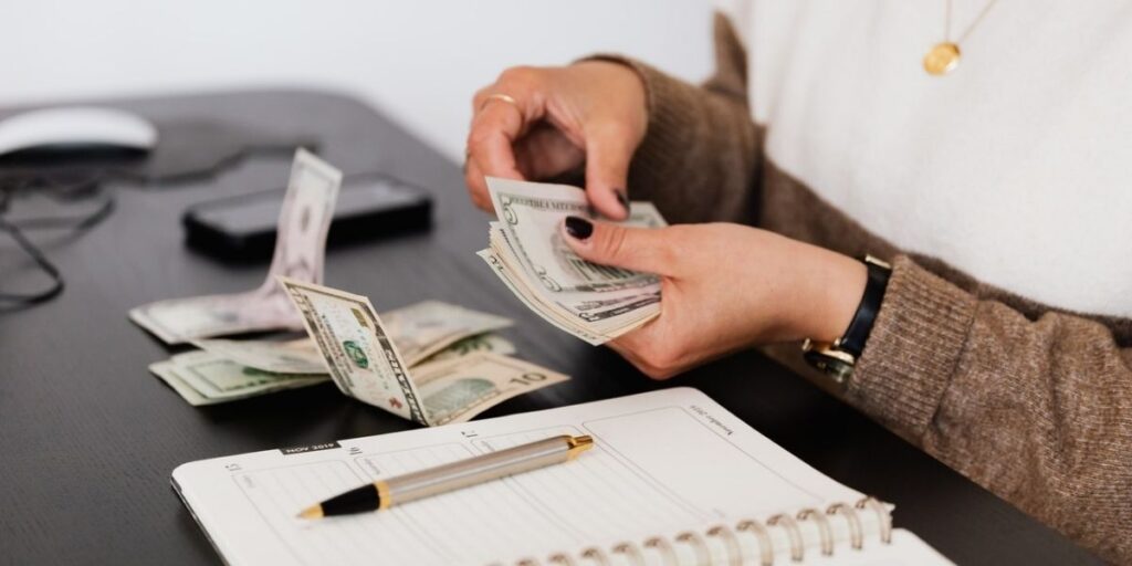 person counting money with a planner